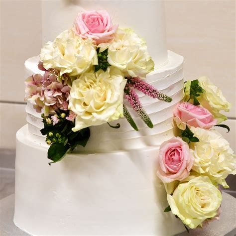 Svadobná torta zdobená figúrkami labutí z fondánu