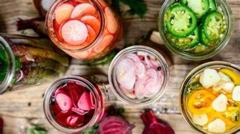 Ilustrácia rôznych druhov fermentovanej zeleniny v pohároch.