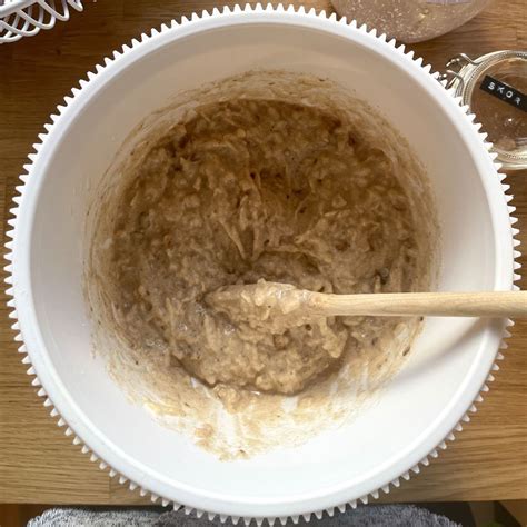 Misa s pripraveným cestom na koláč a ingredienciami v pozadí