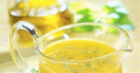 Doma pripravený vinaigrette dresing v miske s čerstvými bylinkami