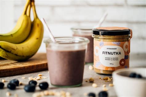 Banánovo-slivkové smoothie v pohári, ozdobené plátkami banánu a čerstvými slivkami