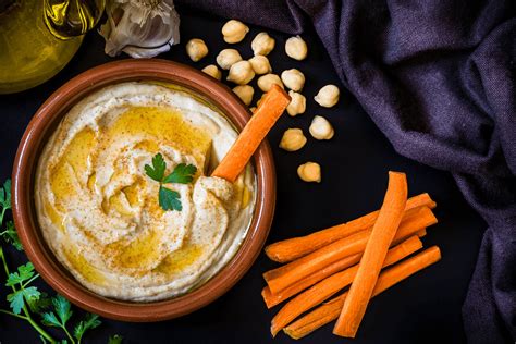 Misky s pripraveným ovocím, zeleninovými tyčinkami a hummusom na rýchly snack