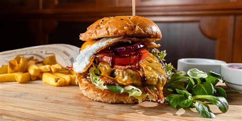 Šťavnatý hovädzí burger s čerstvou zeleninou na grile