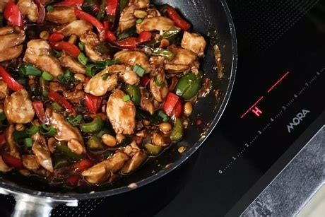 pohľad na hotové kuracie Kung Pao v panvici wok s arašidmi a paprikou