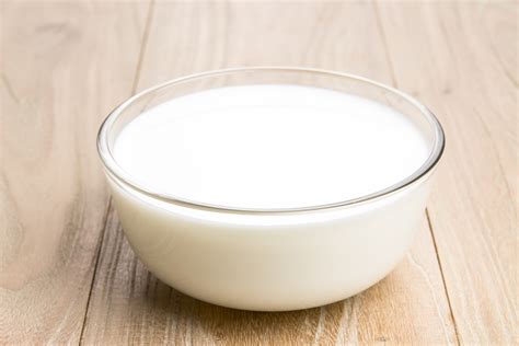Cottage cheese v drevenej miske, mlieko v pohári, vajcia. Farmárske produkty.