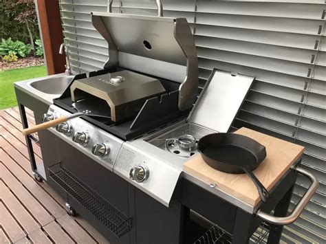 Rodina grilujúca na záhrade s veľkým plynovým grilom