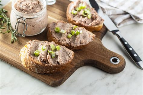 Domáca králičia paštéta podávaná na chlebe s čerstvými bylinkami
