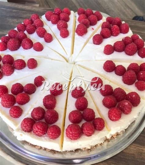 Cheesecake zdobený kopčekmi šľahačky a čerstvými malinami