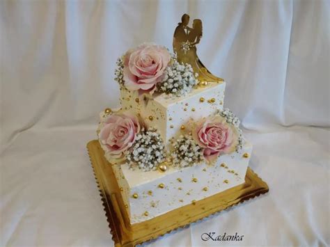Zimná svadobná torta so zlatými detailmi a zasneženými vetvičkami