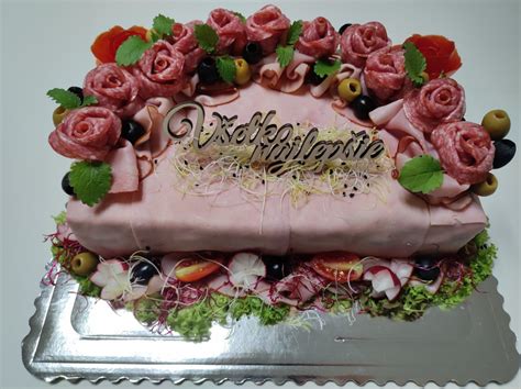 detailné zdobenie slanej torty zeleninou a šunkou