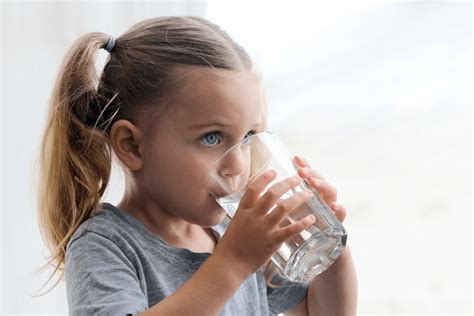 Dáma pije vodu pre lepšiu hydratáciu