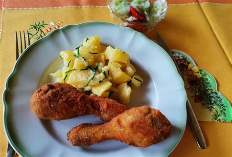 Porcie pečeného kurčaťa so zemiakmi a čerstvým šalátom