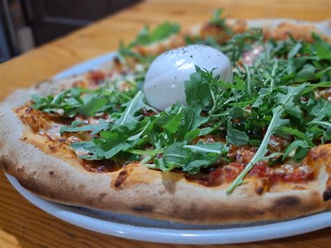 Zákazníci preberajúci pizzu od usmievavého kuriéra