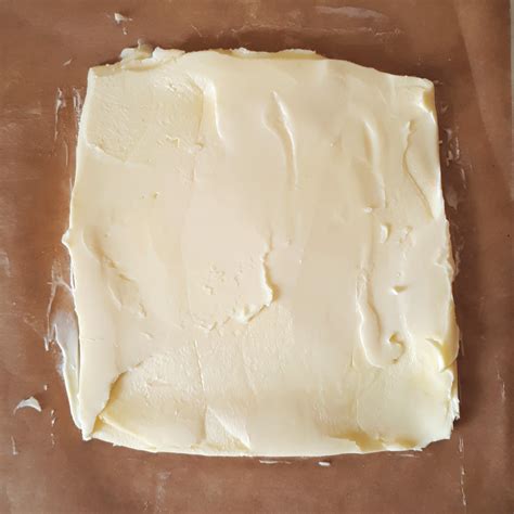 Rozvaľkané maslo medzi papiermi na pečenie