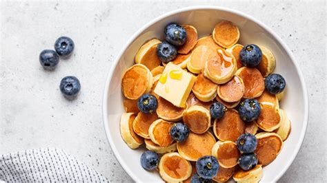 Mini palacinkové cereálie v miske s mliekom a ovocím