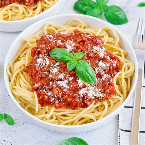 Tanier s hotovými špagetami Bolognese posypanými parmezánom