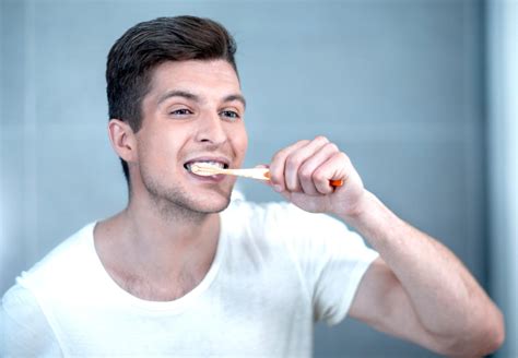 Osoba si čistí zuby aktívnym uhlím
