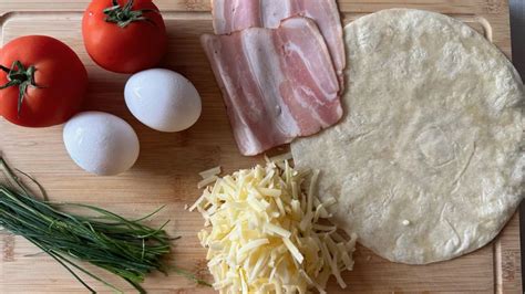 Hotová vaječná tortilla so syrom a zeleninovou náplňou na tanieri