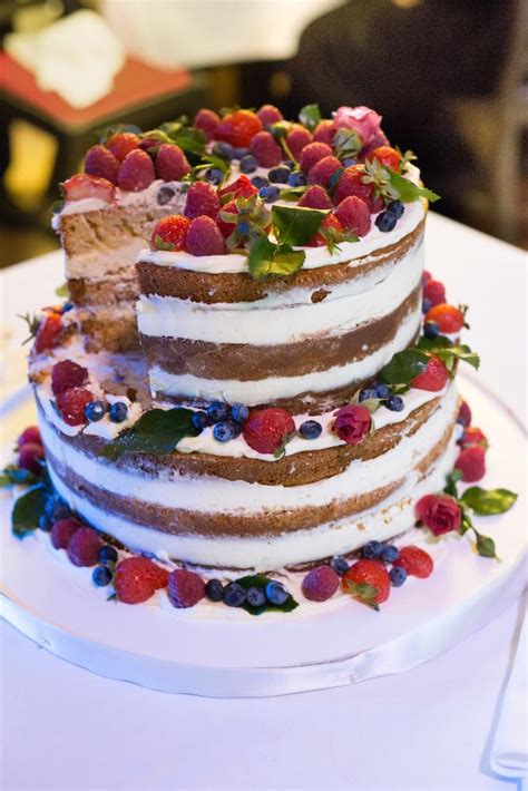 Nahá svadobná torta zdobená kvetmi a ovocím