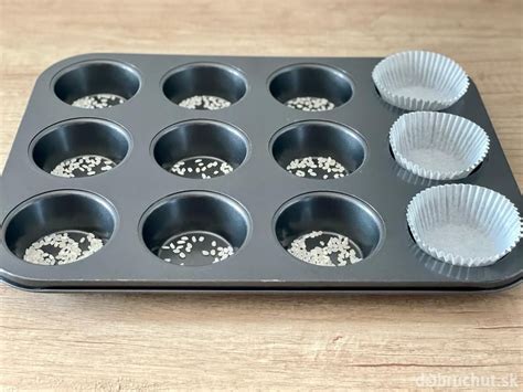 Košíčky na muffiny naplnené cestom pred pečením