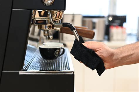 Barista čistí parnú trysku kávovaru po šľahaní mlieka