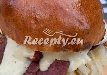 Skladanie hamburgeru s rôznymi prísadami, vrátane karamelizovanej cibule