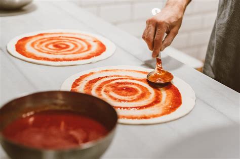 Proces obkladania gazdovskej pizze rôznymi ingredienciami