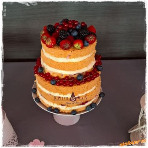 Nahá svadobná torta ozdobená čerstvým ovocím a kvetmi