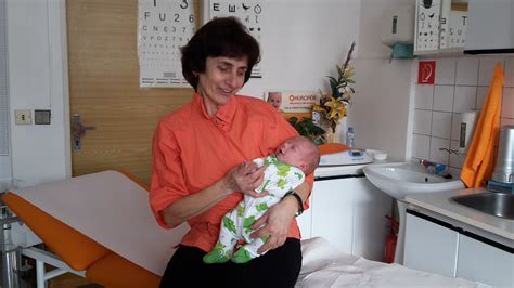 Detský lekár sa usmieva a drží bábätko
