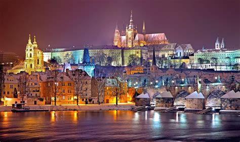 Panoramatický pohľad na osvetlený Pražský hrad z Vltavy v noci