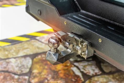 Mechanik montuje ťažné zariadenie na auto na zdviháku