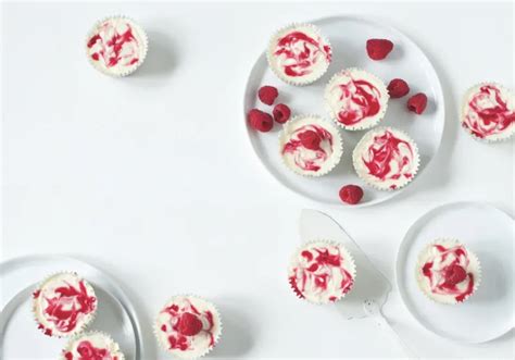 Hotové mini cheesecaky s bielou čokoládou a malinami