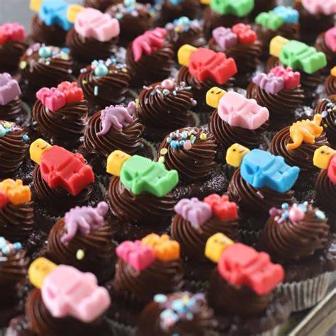 čokoládové cupcakes s farebnou šľahačkou a detskými ozdobami