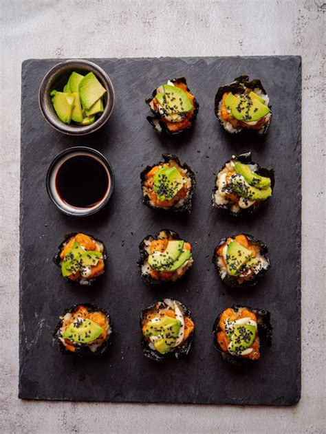 detailný záber na krájanie sushi rolky s avokádom a lososom
